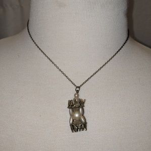 Vintage pearl and metal pendent on chain.